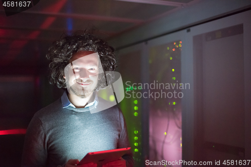 Image of IT engineer working on a tablet computer in server room