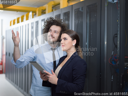 Image of engineer showing working data center server room to female chief