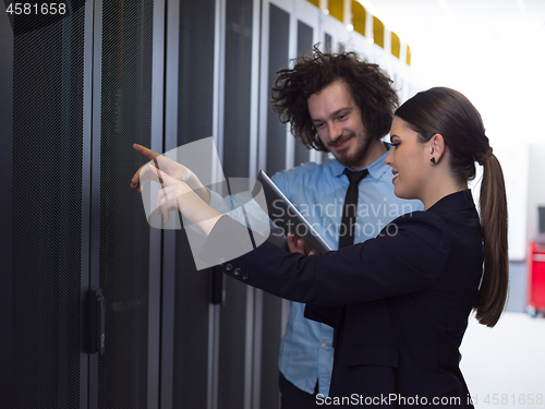 Image of engineer showing working data center server room to female chief