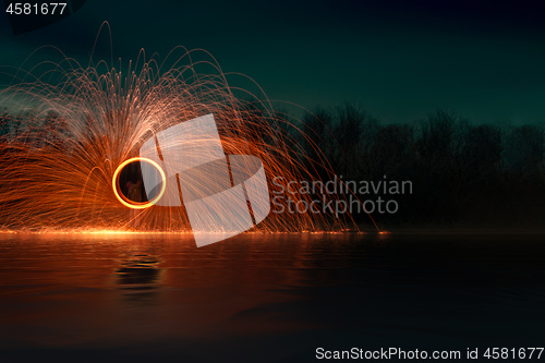 Image of steel wool firework at night at the lake