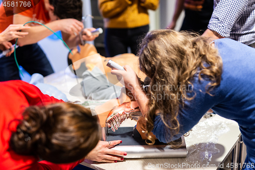 Image of Medical doctor specialist expert displaying method of patient intubation on hands on medical education training and workshop. Participants learning new medical procedures and techniques.