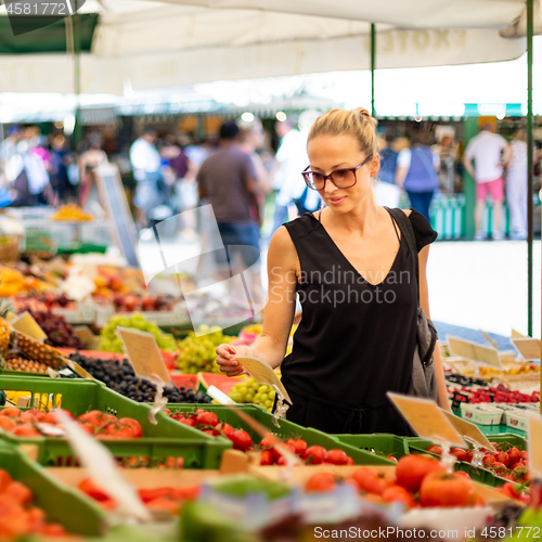 Image of Woman buying fruits and vegetables at local food market. Market stall with variety of organic vegetable