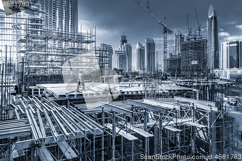 Image of Laborers working on modern constraction site works in Dubai. Fast urban development consept