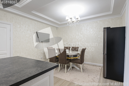 Image of White luxury modern kitchen with dining table and island