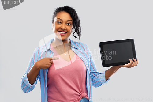 Image of happy african american woman showing tablet pc