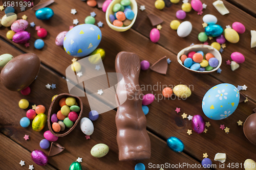 Image of chocolate eggs, easter bunny and candies on wood