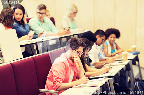 Image of group of students with notebooks in lecture hall