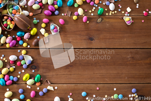 Image of chocolate eggs and candy drops on wooden table