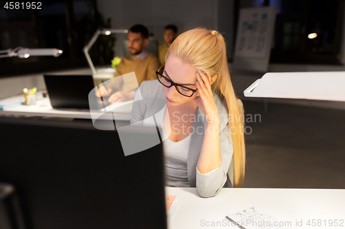 Image of tired businesswoman working at night office