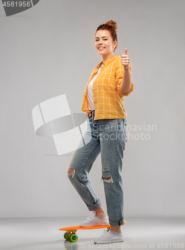 Image of teenage girl with skateboard showing thumbs up