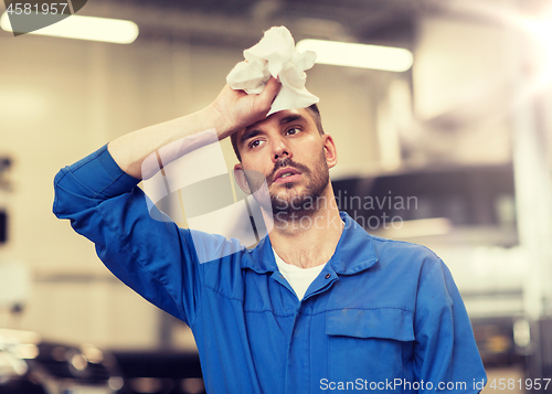 Image of tired auto mechanic man or smith at car workshop