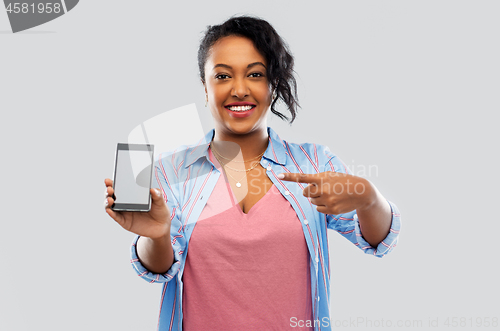 Image of happy african american woman showing smartphone