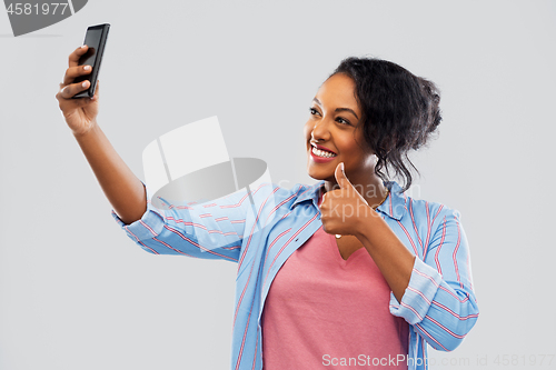 Image of african american woman taking selfie by smartphone