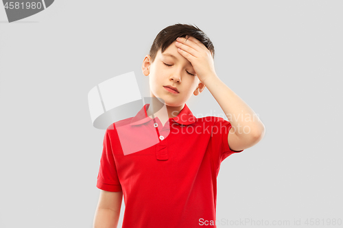 Image of sick boy in red t-shirt suffering from headache