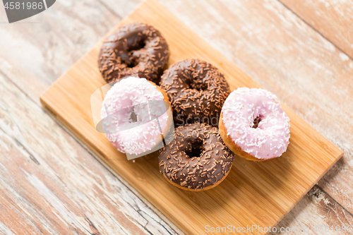 Image of close up of glazed donuts pile on wooden board