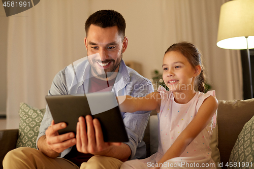 Image of father and daughter with tablet computer at home