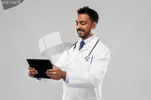 Image of smiling indian male doctor with tablet computer