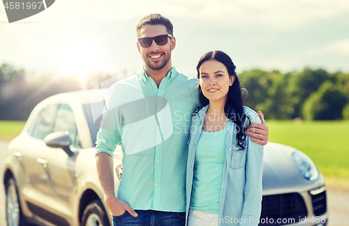 Image of happy man and woman hugging at car