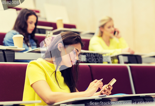 Image of student girls with smartphones on lecture