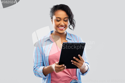 Image of happy african american woman using tablet pc