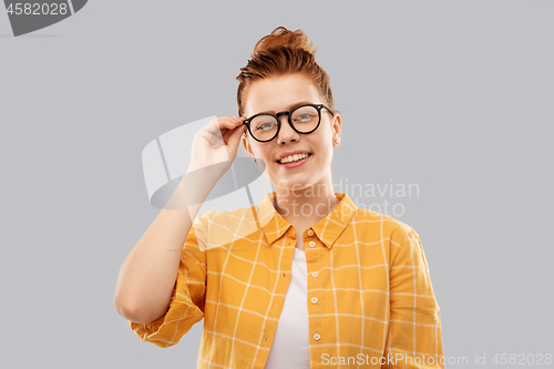 Image of smiling red haired teenage student girl in glasses