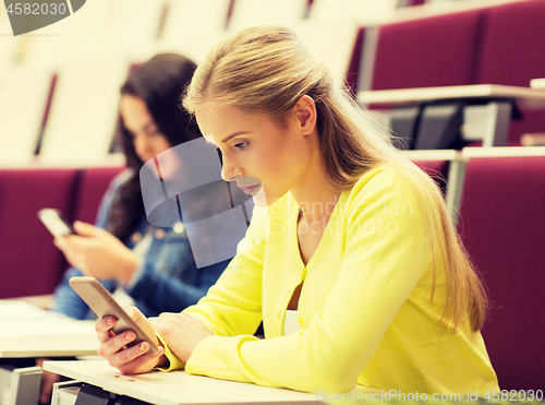 Image of student girls with smartphones on lecture