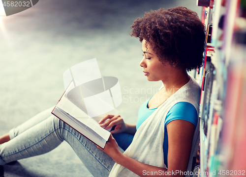 Image of african student girl reading book at library