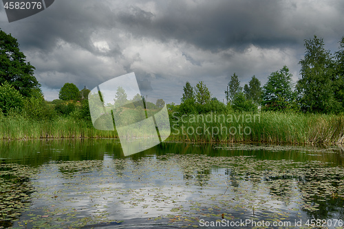 Image of Reflections in a lake with sky and trees