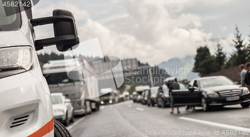 Image of Typical scene on European highways during summer holiadays rush hour. A traffic jam with rows of cars tue to highway car accident. Empty emergency lane. Shallow depth of field