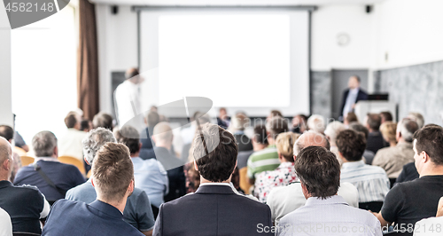 Image of I have a question. Group of business people sitting in conference hall. Businessman raising his arm. Conference and Presentation. Business and Entrepreneurship