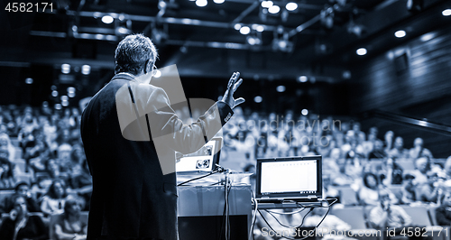 Image of Public speaker giving talk at Business Event.