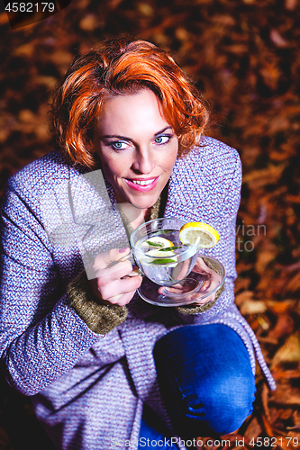 Image of portrait of a smiling young woman drinking glass