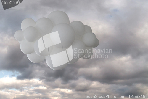 Image of White helium balloons on a cloudy sky background.