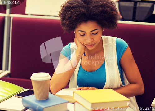 Image of student girl with books and coffee on lecture