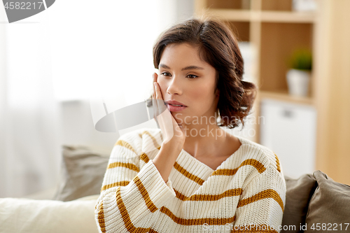 Image of unhappy woman suffering from toothache at home