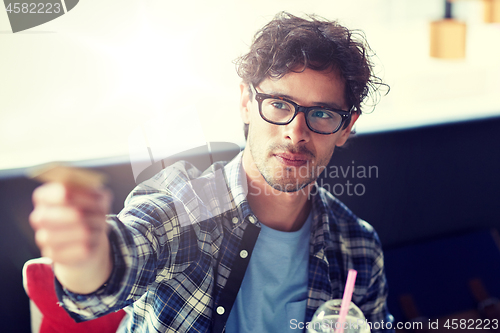 Image of happy man paying with credit card at cafe