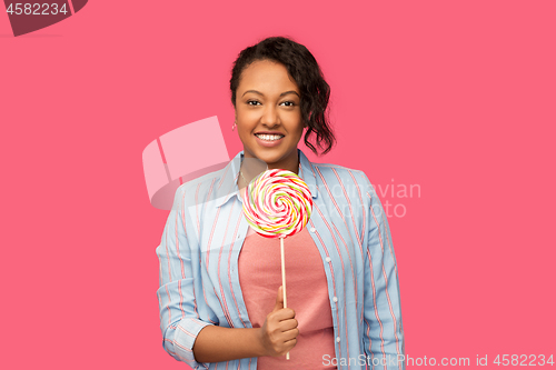 Image of happy african american woman with big lollipop