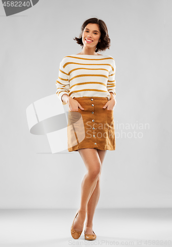 Image of young woman in striped pullover, skirt and shoes