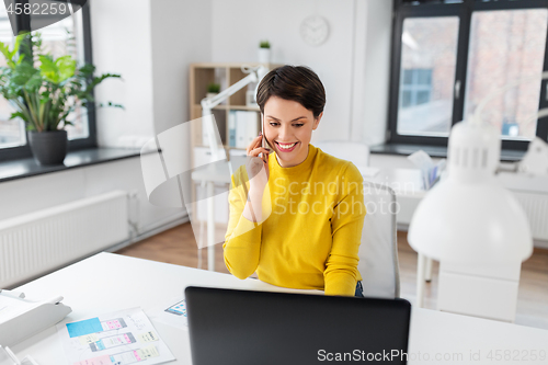 Image of happy ui designer calling on smartphone at office