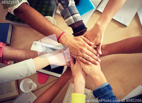 Image of group of international students with hands on top