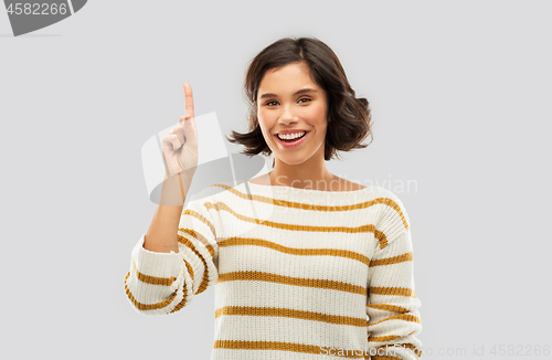 Image of happy woman showing one finger or pointing up