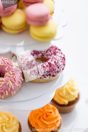 Image of close up of glazed donuts and cupcakes on stand