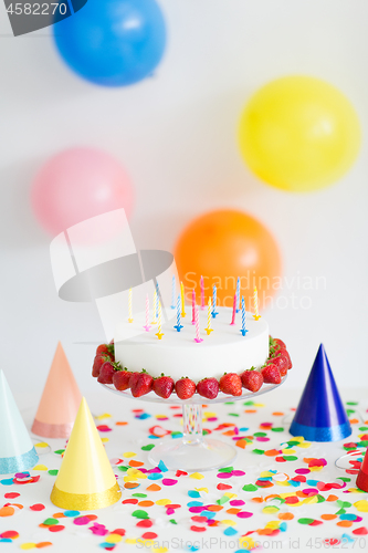 Image of birthday cake with candles and strawberries