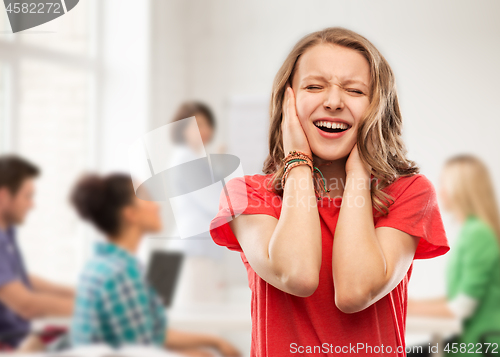 Image of annoyed teenage girl covering her ears with hands