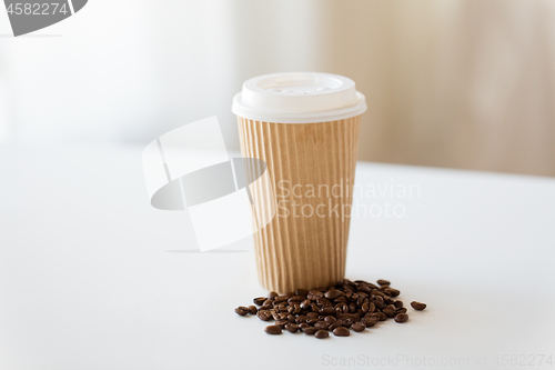 Image of close up cup and roasted coffee beans on table