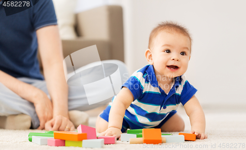 Image of baby boy with father playing toy blocks at home