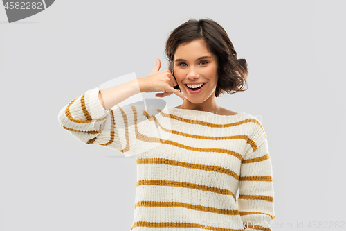 Image of happy smiling woman showing phone call gesture