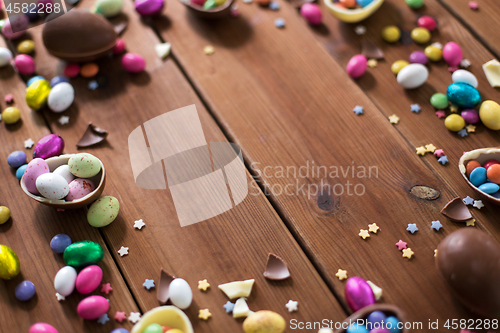 Image of chocolate eggs and candy drops on wooden table