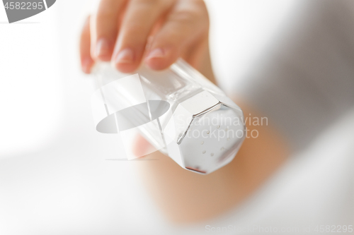 Image of close up of hand holding salt cellar