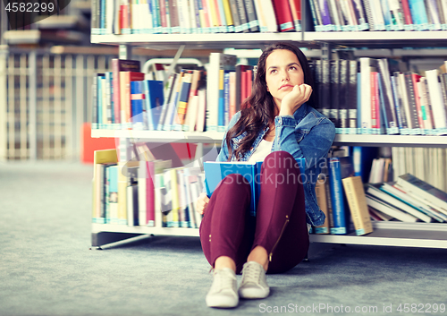 Image of high school student girl reading book at library